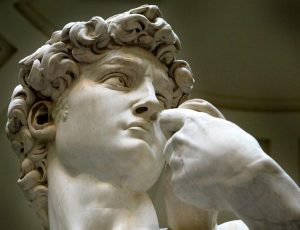 Close-up detail shows Michelangelo's statue of David at the Accademia museum in Florence